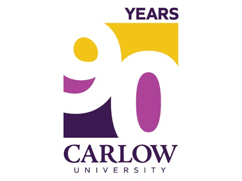 Logo for Carlow’s 90th anniversary is a white rectangle with the numeral 90 in white with a purple and yellow background.