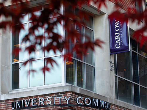 A corner of University Commons with a purple Carlow banner.