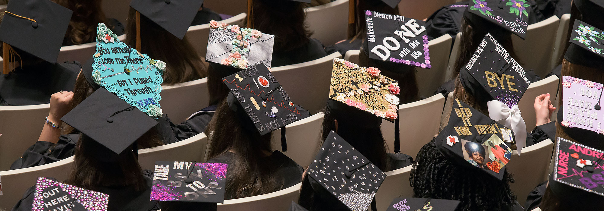 View from above shows graduation caps decorated with messages.