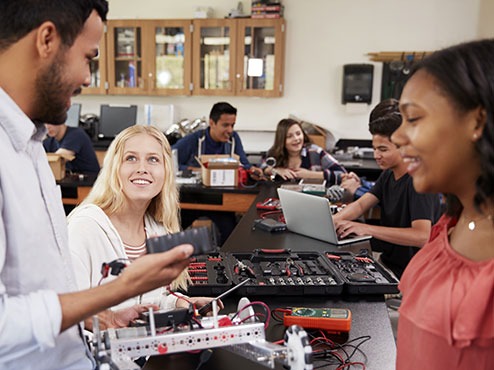 MEd in STEM Teaching students talking and messing with gadgets