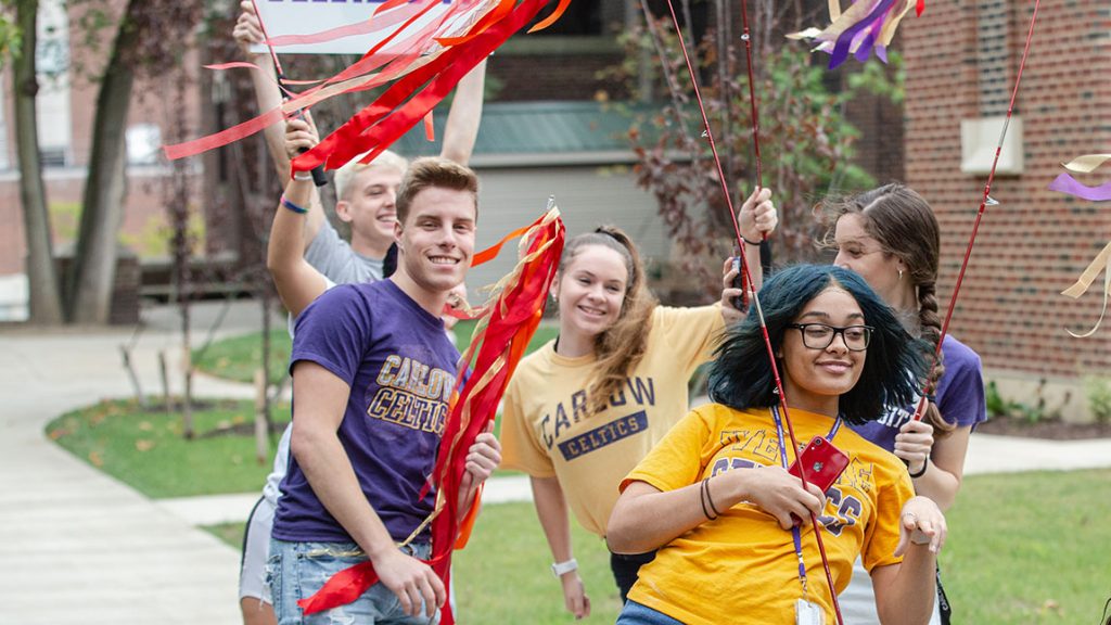 Students wearing Carlow Celtics shirts celebrate on campus.
