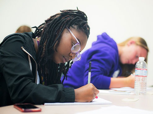 Transfer students work intently at their desks in a classroom.