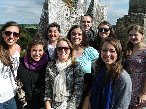 A group of Carlow students posed in front of a rock on a study abroad trip.