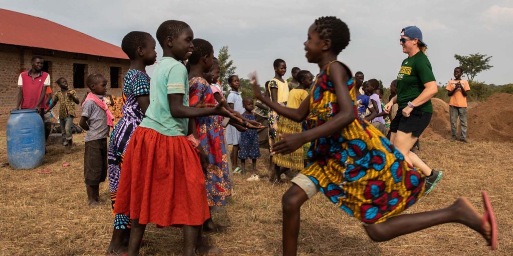 Ugandan children running outside in their community.