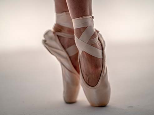close up photo of two ballet slippers on a dancers feet.