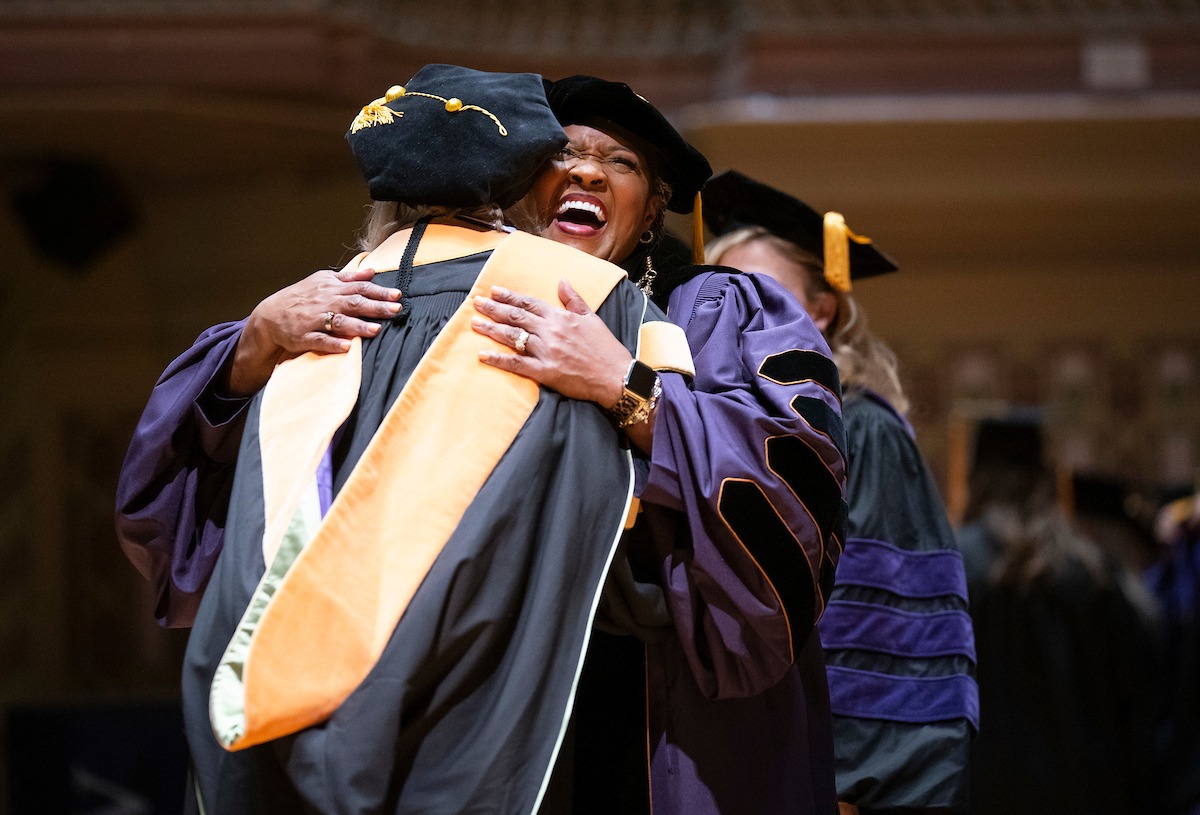 Dr. Humphrey hugs a graduate at the Commencement ceremony.