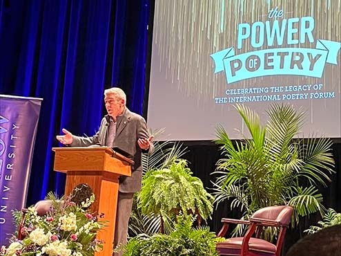 Richard Blanco at the podium on the stage at the Power of Poetry event.