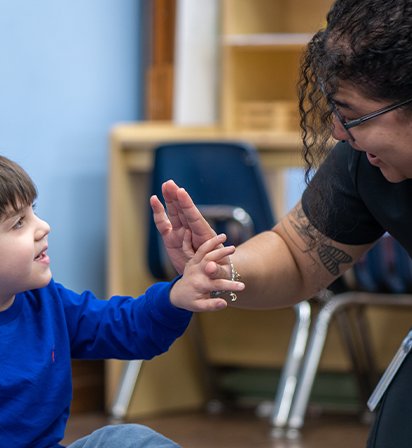 Carlow student high-fiving a young child