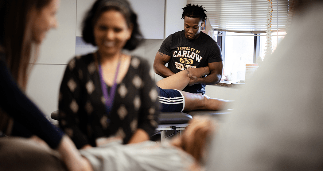 A Carlow University physical therapy student working with a patient while faculty observe