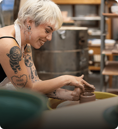 A Carlow art student shaping clay on a pottery wheel